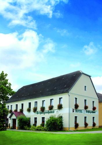 a large white building with a black roof at Hotel Schützenhaus Jessen in Jessen