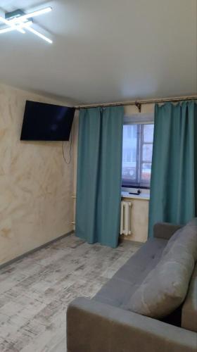 a living room with a couch and a window at Подобово Центр in Konotop