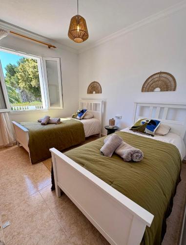 a bedroom with two beds and a window at La FINCAD4 entre plages et Forêt in Son Parc