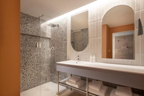 a bathroom with a sink and a mirror at Parkest Hôtel & Spa in Genas