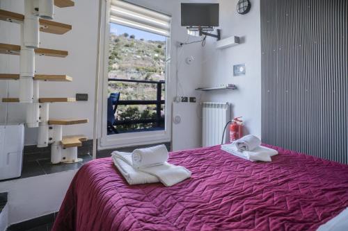 a bedroom with a purple bed with towels on it at Cinque Terre, Sea View Home in Manarola