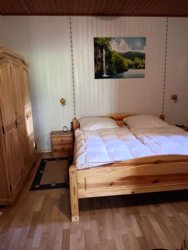 a bedroom with a bed with a picture on the wall at Ferienwohnung Sausen in Kröv