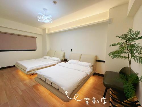 two beds in a room with a projector screen and a plant at Up villa in Taibao
