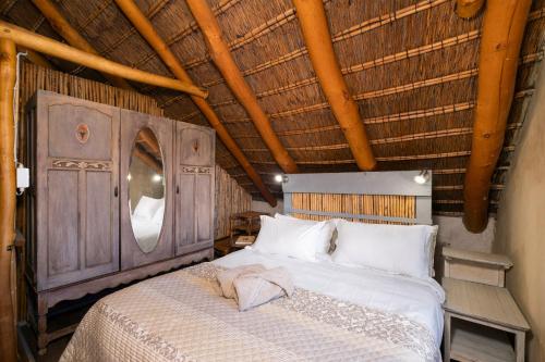 a bedroom with a bed with a wooden ceiling at Duivenvlugt Loft in Stilbaai
