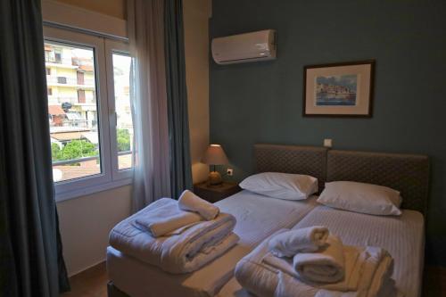 a bedroom with two beds with towels and a window at G. Kiapekou in Loutra Edipsou