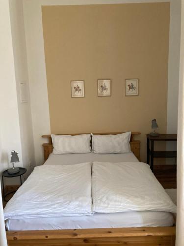 a bed with white sheets and pillows in a bedroom at Apartment Schloss Benrath in Greifswald