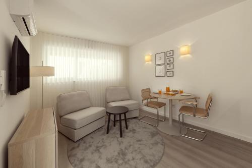 a living room with a chair and a table at Casa Jacinto 9 in Caldas da Rainha