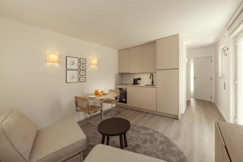 a white living room with a couch and a table at Casa Jacinto 9 in Caldas da Rainha