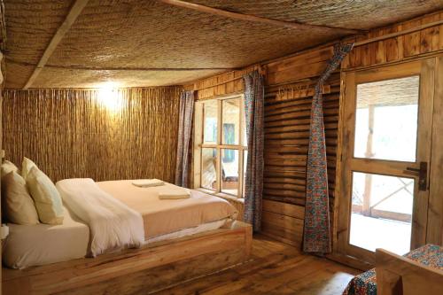 a bedroom with a bed in a room with wooden walls at Noble Cheer in Ruhengeri