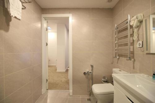 a bathroom with a toilet and a sink at Noor-ZamZam-Madinah Halal Hotels Group in Baku