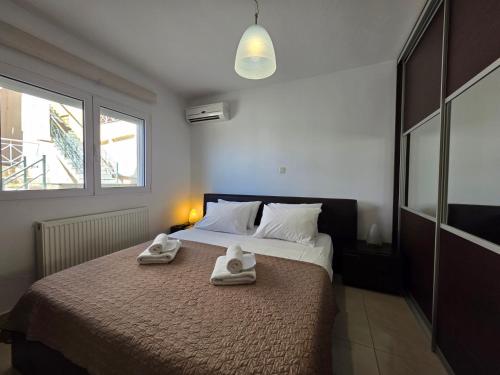 a bedroom with a bed with two towels on it at Peramos Sea View in Nea Peramos