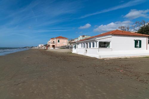 a white building on the side of a beach at Villa in Spiaggia in Follonica