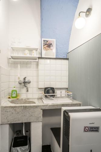 a small kitchen with a sink and a microwave at La Stanza Rossa alle Cinque Terre in Manarola