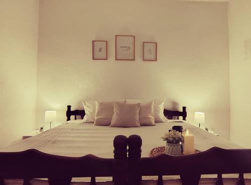 a bedroom with a large bed with two pictures on the wall at Bistrički mir - Rustic House in Petrovac na Mlavi