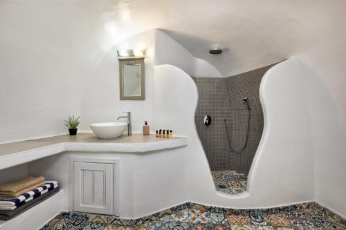 a bathroom with a sink and a shower at ROCK CAVE HOUSE in Oia