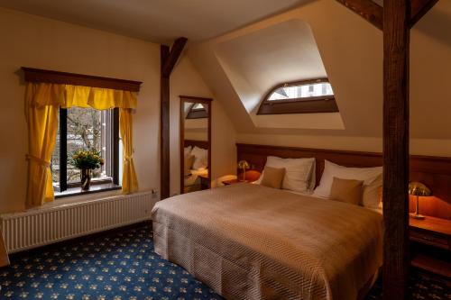 a bedroom with a large bed and a window at LH Hotel Gold in Český Krumlov
