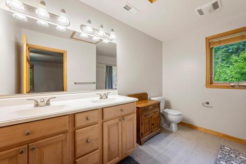 a bathroom with a sink and a mirror and a toilet at Shenandoah A-Frame Chalet at Bryce Resort in Basye