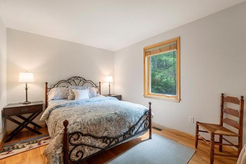 a bedroom with a bed and a chair and a window at Shenandoah A-Frame Chalet at Bryce Resort in Basye