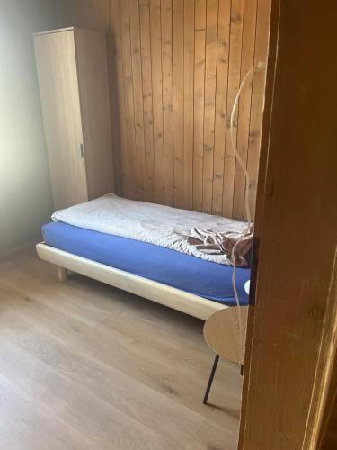 a small bedroom with a bed in a wooden wall at Landliebi 3-room apartment in Faulensee