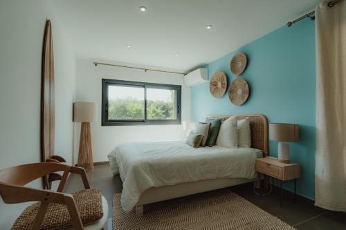a bedroom with a bed with a blue wall at Villa Ryx avec piscine in Grimaud