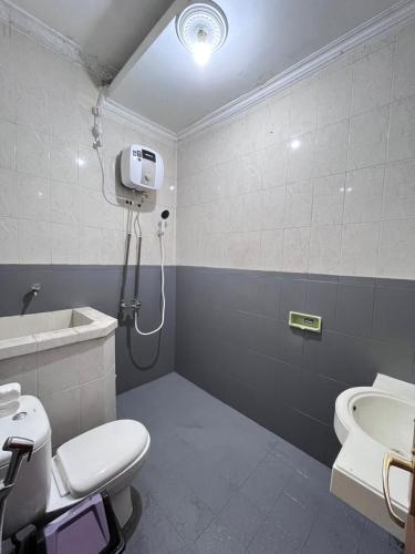 a bathroom with a shower and a toilet and a sink at Bromo Breeze Malang in Malang