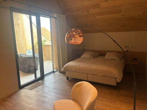 a bedroom with a bed and a lamp and a chair at Tjusteplekske in Heuvelland