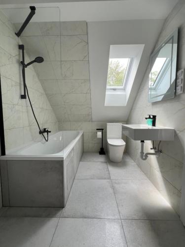 a bathroom with a tub and a toilet and a sink at Garda Apartman in Balatonfenyves