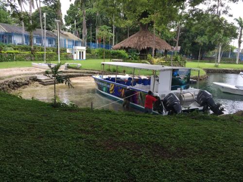 a small boat is docked in a river at Madang Resort in Madang