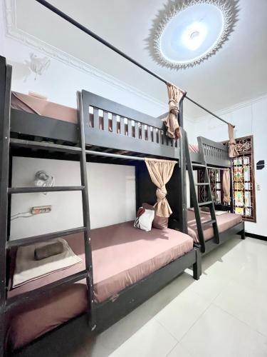 a bedroom with two bunk beds and a chandelier at Bromo Breeze Malang in Malang