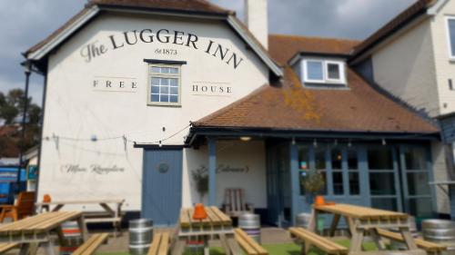 a tree house with picnic tables in front of it at The Lugger Inn in Weymouth