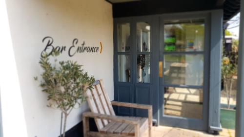 a wooden bench sitting outside of a building with a door at The Lugger Inn in Weymouth