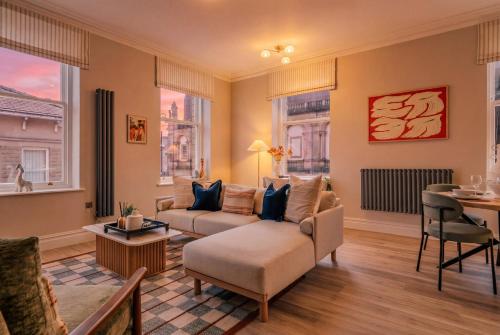 a living room with a couch and a table at St James Apartments - Harrogate in Harrogate