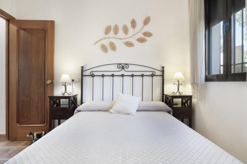 a bedroom with a large white bed with two night stands at La Pedrosa in La Cimada