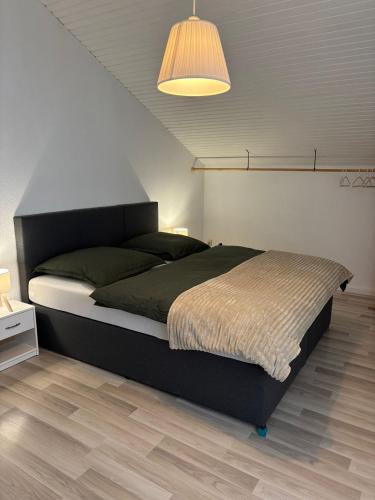 a bedroom with a large bed with a lamp at Lakehouse Nour in Bell