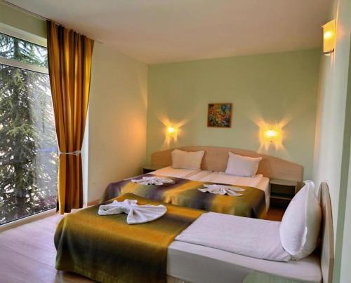 a hotel room with two beds and a window at Dalis Sunny Beach in Sunny Beach