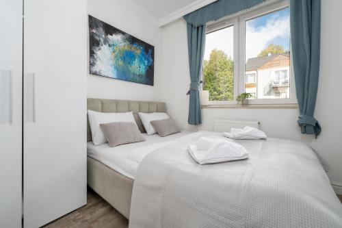 two beds in a bedroom with a window at Apartamenty Izerskie - ul. Cicha 13D-E in Świeradów-Zdrój
