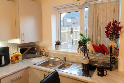 a kitchen with a sink and a window at Bright 4 Bedroom Home in Walsall, Free Parking and for EVs in Walsall