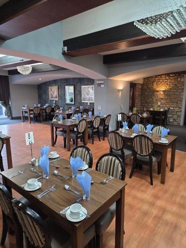 a large dining room with wooden tables and chairs at Wessex Hotel in Street