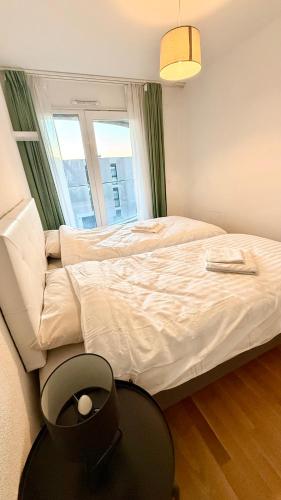 a bedroom with a bed with a table and a window at Cape Homes St-Sulpice in Saint-Sulpice