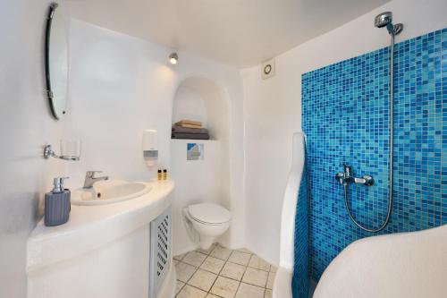 a bathroom with a shower and a toilet and a sink at VITAMIN STUDIO in Oia
