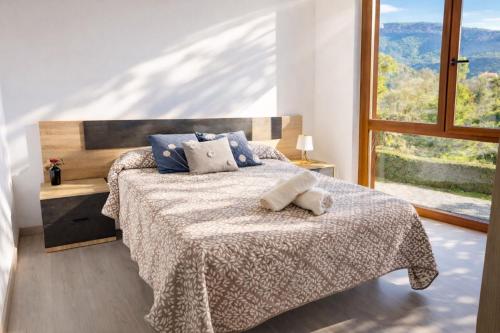 a bedroom with a bed and a large window at Apartament Gritella ( Cim Apartaments ) in Cornudella