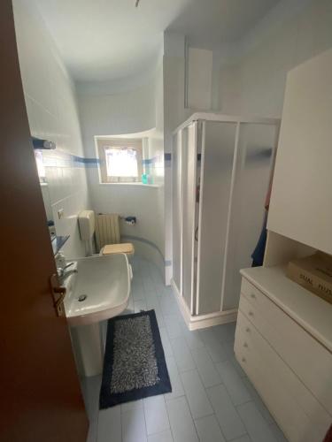 a white bathroom with a sink and a shower at La Villetta in Giulianova