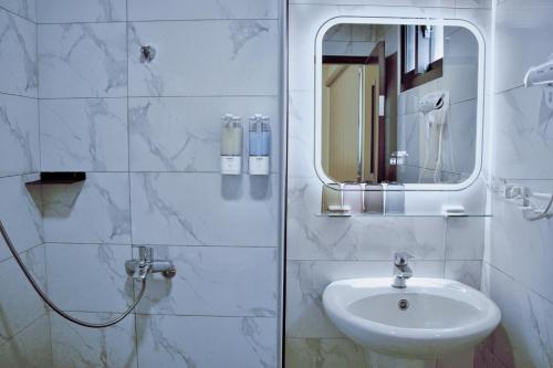 a white bathroom with a sink and a mirror at Up villa in Taibao