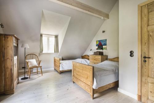 a bedroom with a bed and a desk and a chair at Kleiner Caecilienhof in Pommerby