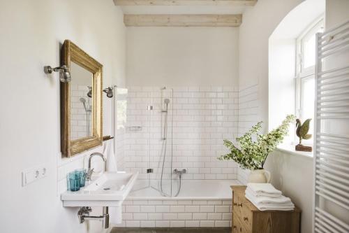 a white bathroom with a sink and a shower at Kleiner Caecilienhof in Pommerby
