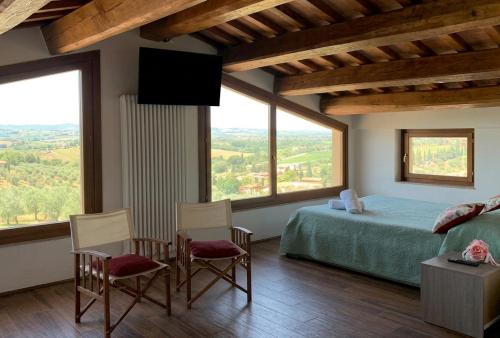 a bedroom with a bed and a large window at Corte Fratini Appartamenti in Trevi
