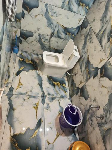 a bathroom with a toilet on a tiled floor at Budget couple rooms vattavada in Vattavada