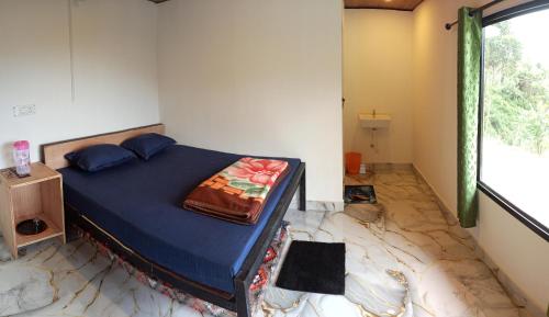 a bedroom with a blue bed with a marble floor at Budget couple rooms vattavada in Vattavada