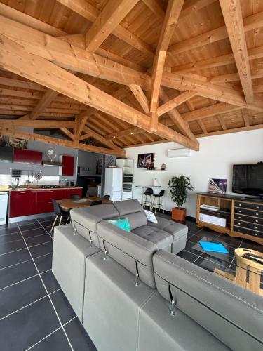a living room with couches and a wooden ceiling at Mon Hacienda in Caumont