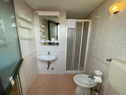 a bathroom with a toilet and a sink at Apartament 2 bedroom with one bathroom and penthouse Apartament 3 bedroom and 2 bathroom included with umbrella and sunbeds in Lido Adriano